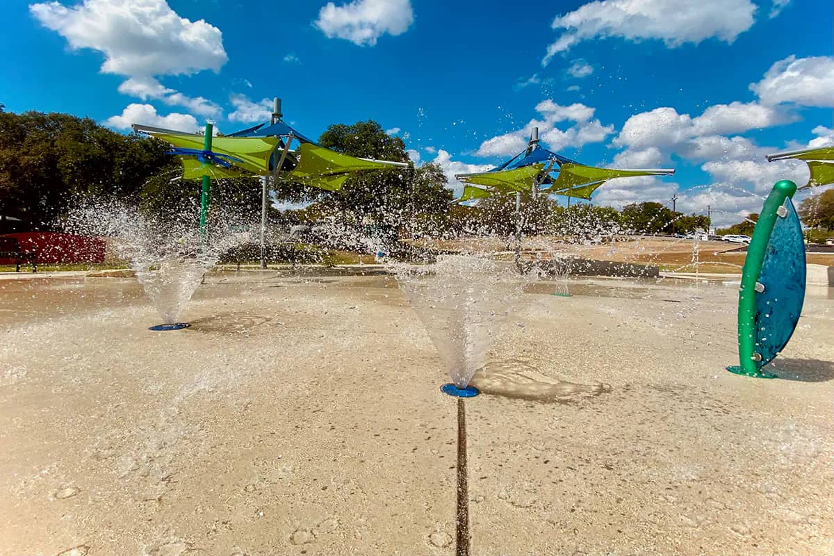 Upspraying water fountains at Lincoln Park splash area in San Antonio.