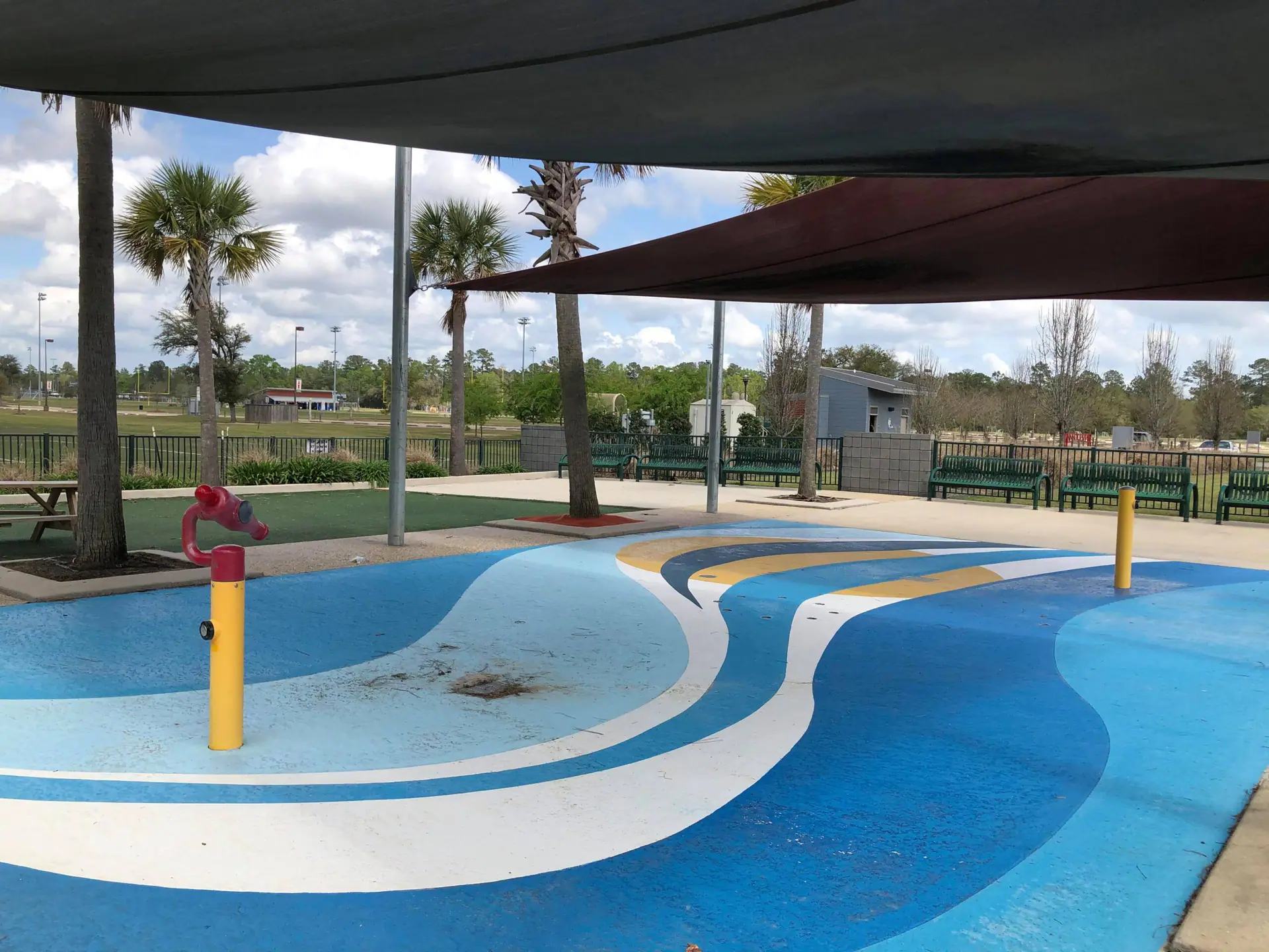 Children playing at the Abita Springs Park splash pad beside the trailhead park area.