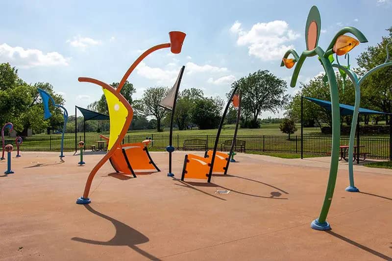 Boomer Lake Splash Pad in Stillwater with spray features and seating nearby.