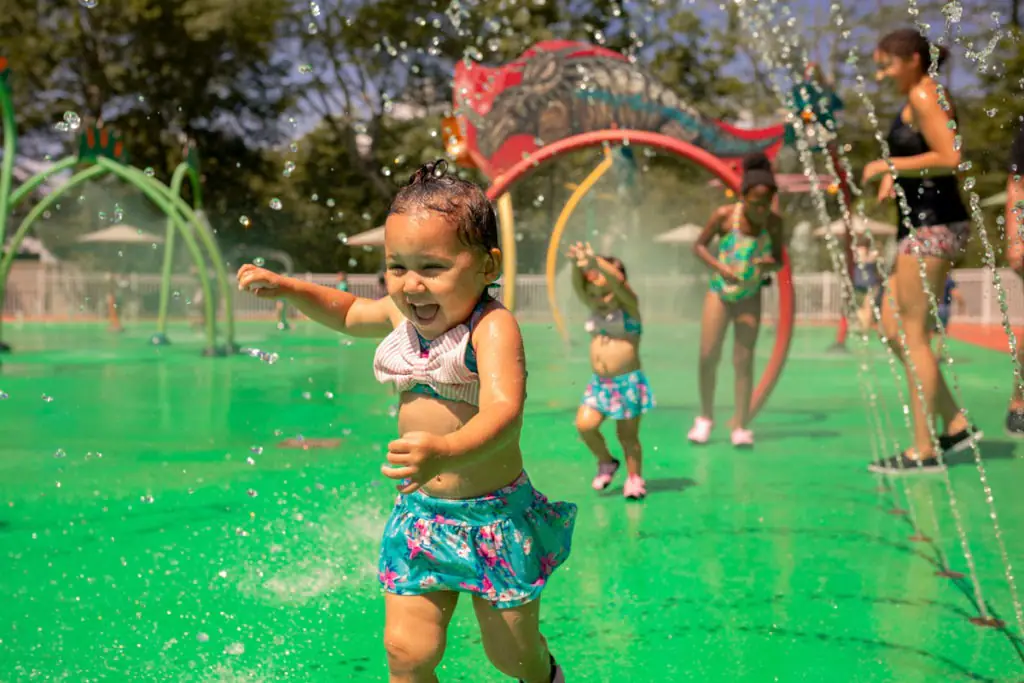 Children playing in the dinosaur-themed splash pad at The Dinosaur Place in Oakdale.