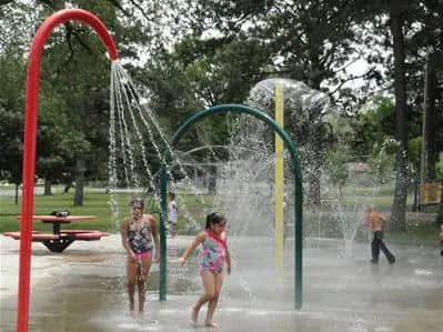 Children playing beneath a spray feature at Jackson Spray Park in Topeka.