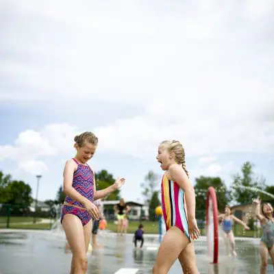 Kids using spray features at a Minot splash pad.