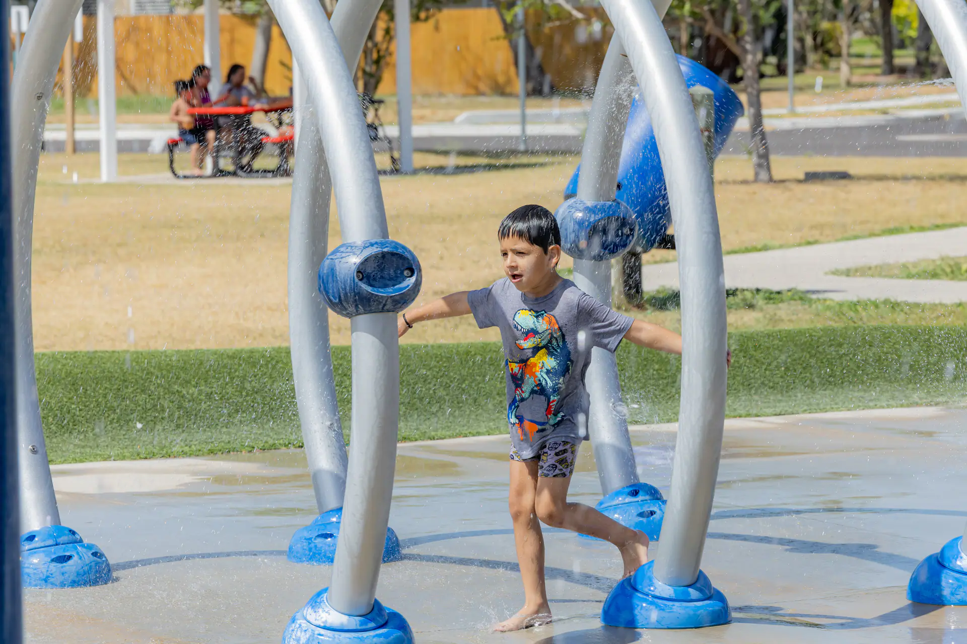 Child running through water at Lindale Park Splash Pad.
