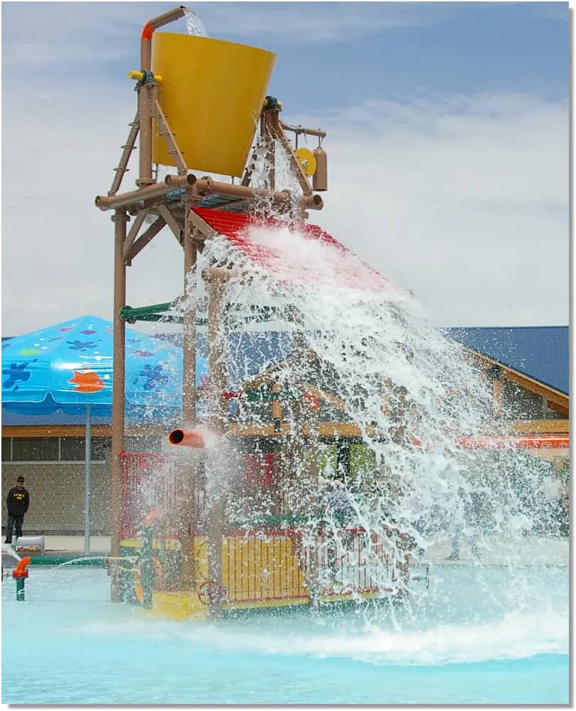 Safari Falls play area at The Falls Aquatic Center in Cedar Falls with shallow water and dump-bucket features.